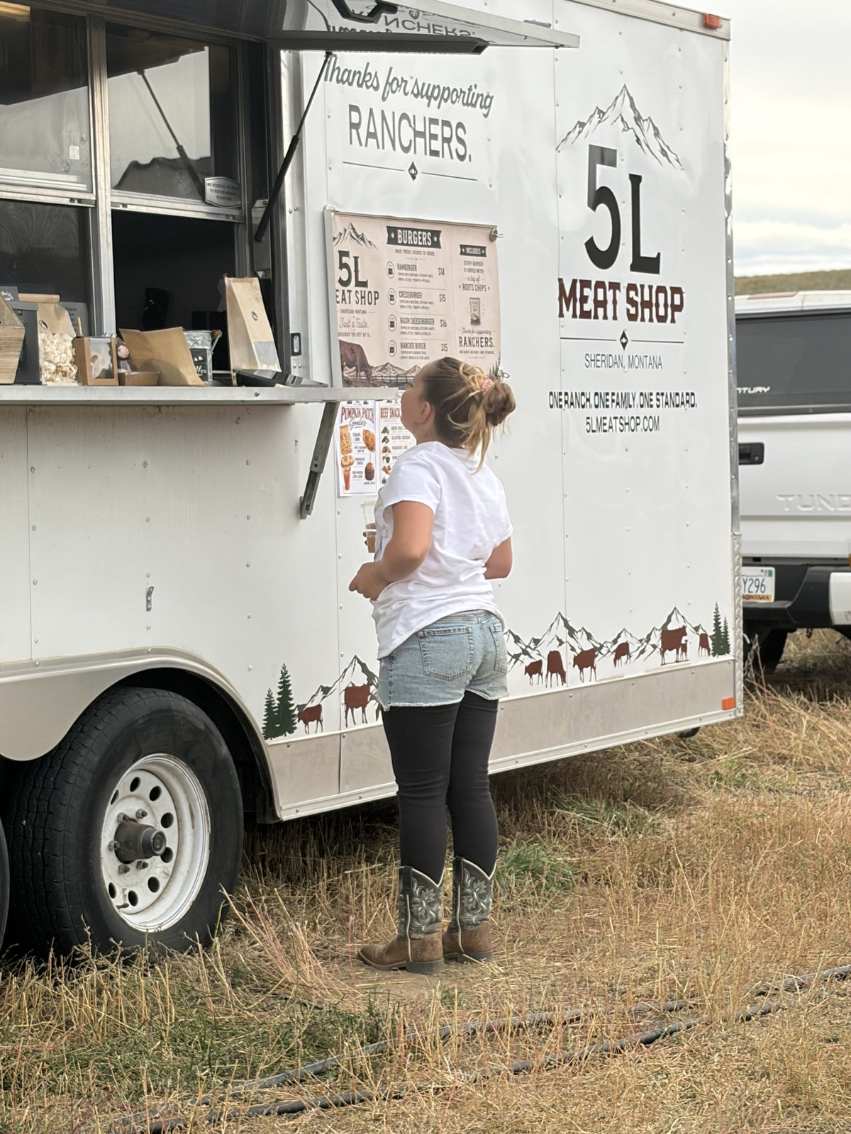 A customer ordering at the 5L burger trailer window