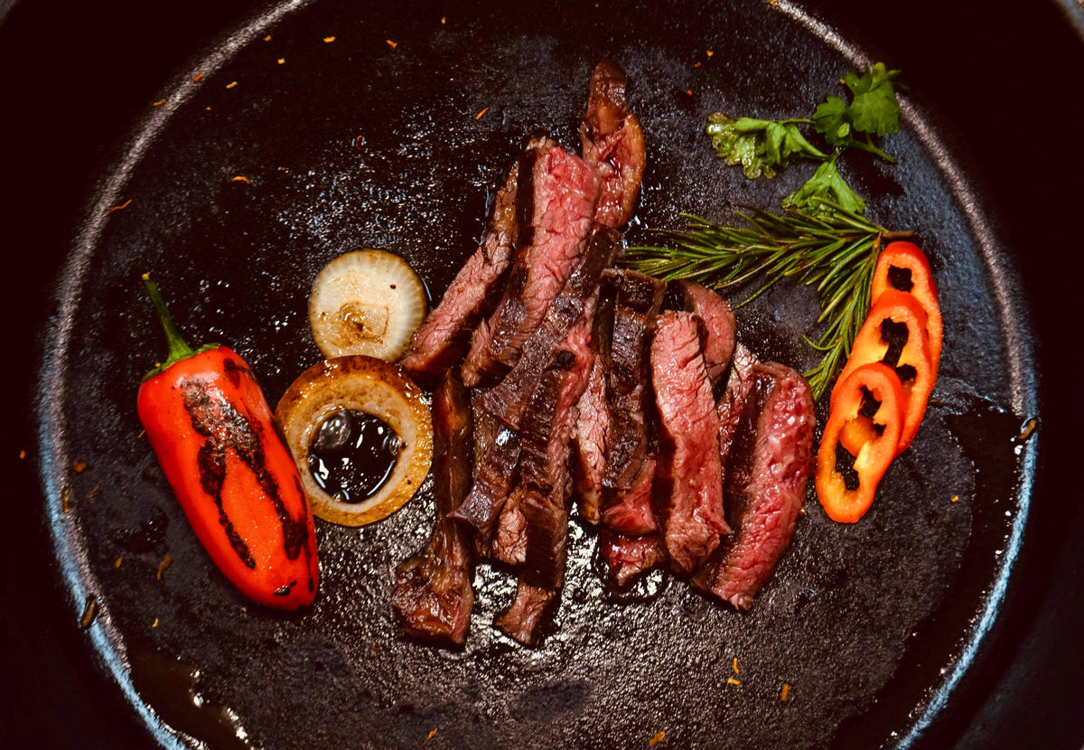Sliced cooked steak with peppers and onions