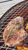 5L steaks grilling over an open flame